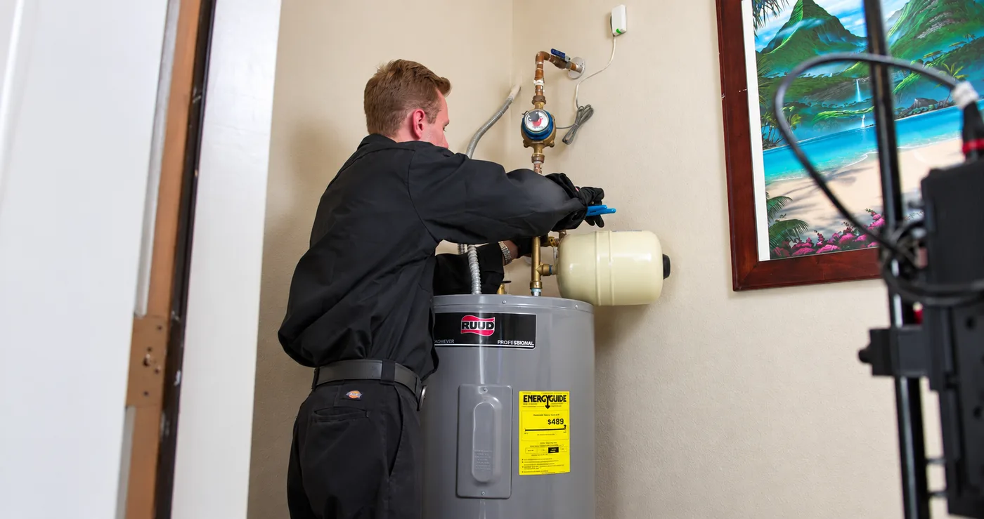 Technician connecting an expansion tank on a water heater