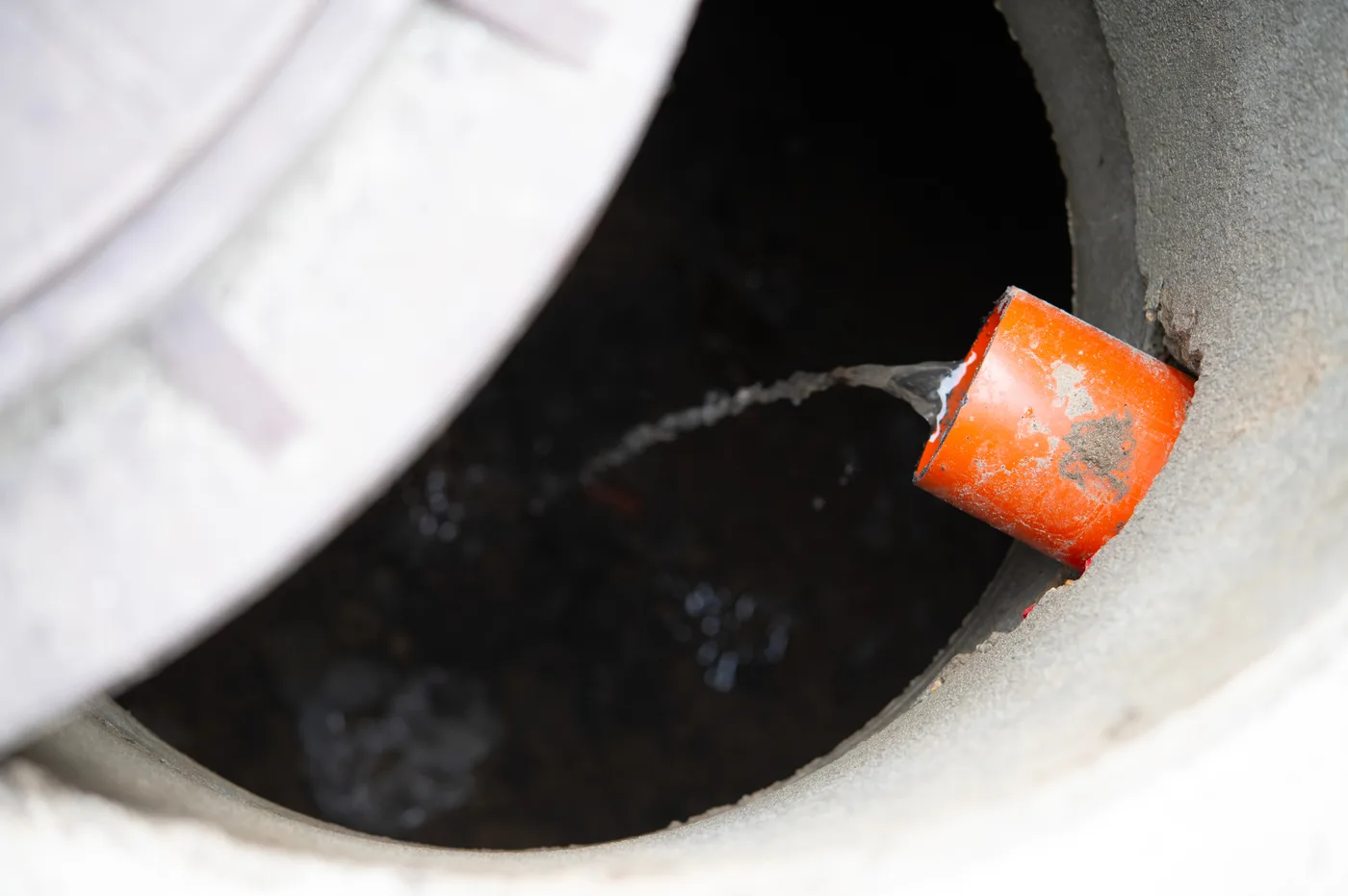 Sewer line discharging into a manhole