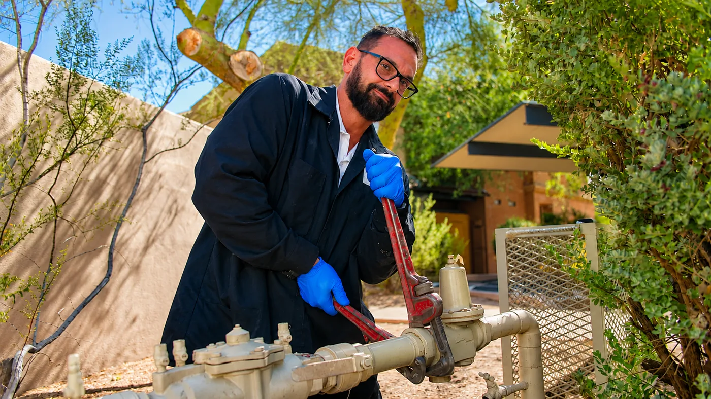 Now plumbing technician servicing an outdoor water line