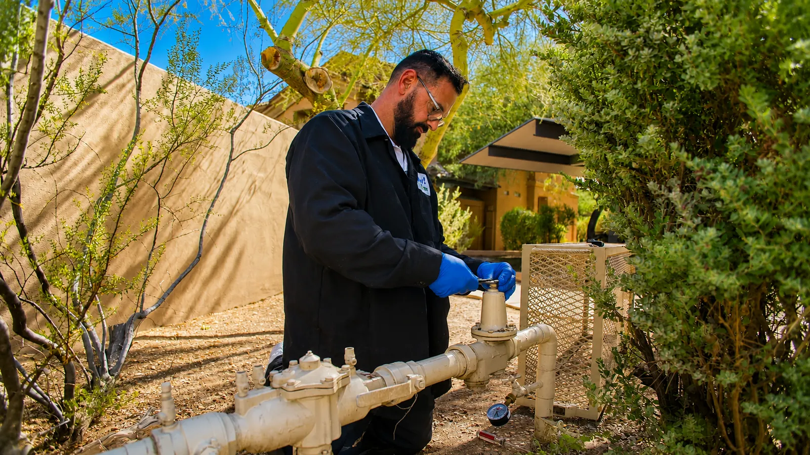 Plumber adjusting an outdoor water pressure regulator